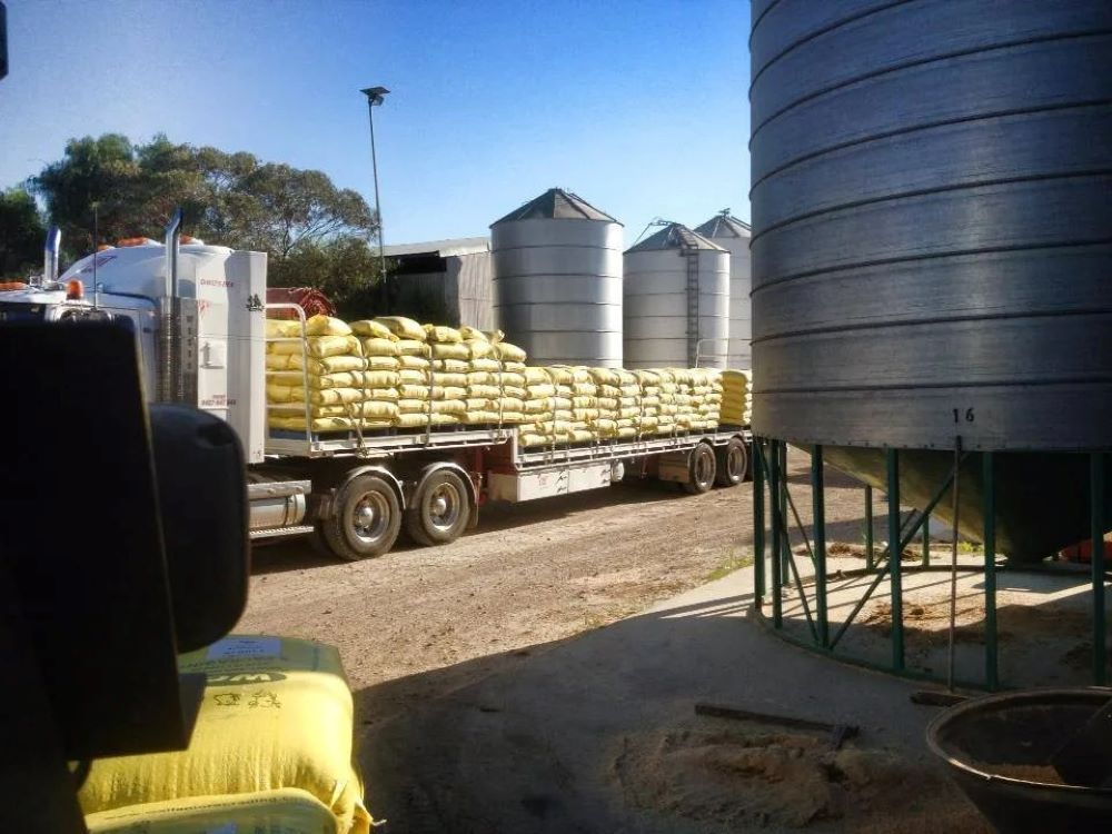 A Truck is Carrying Bags of Grain on the Back of It — Wallamore Grain & Produce In Armidale, NSW
