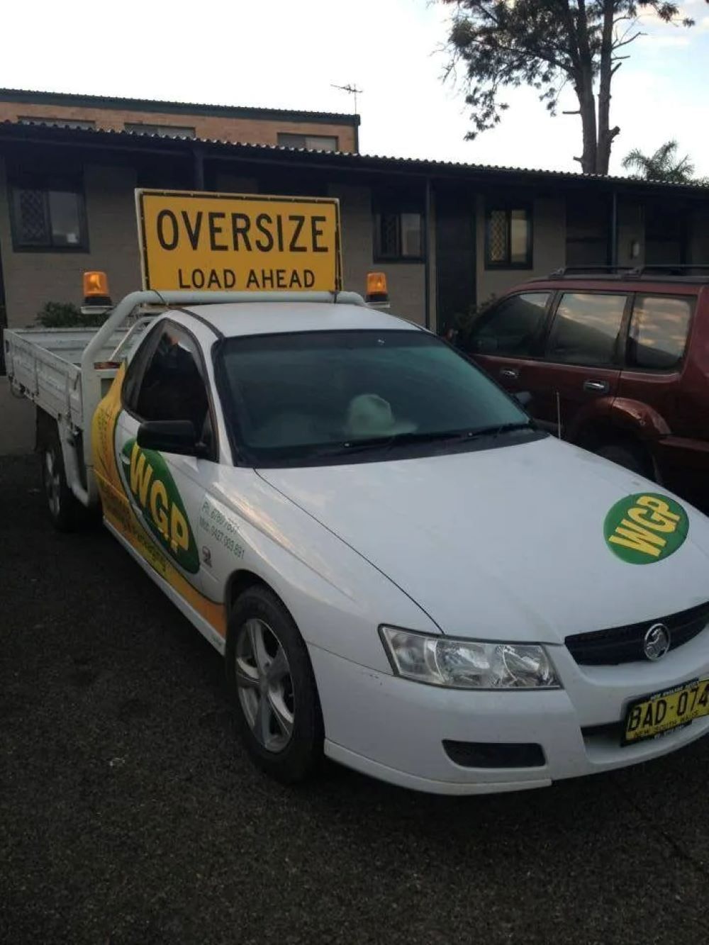A White Truck With an Oversize Load Ahead Sign on Top — Wallamore Grain & Produce In Wallamore, NSW
