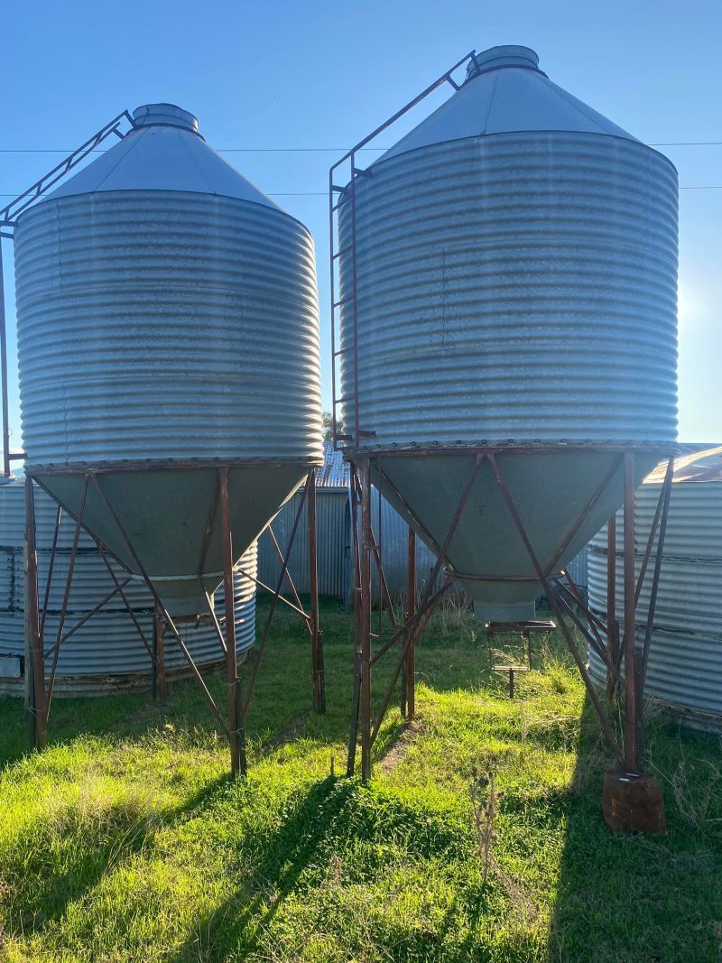 Two Silos Are Sitting Next to Each Other in a Grassy Field — Wallamore Grain & Produce In Wallamore, NSW
