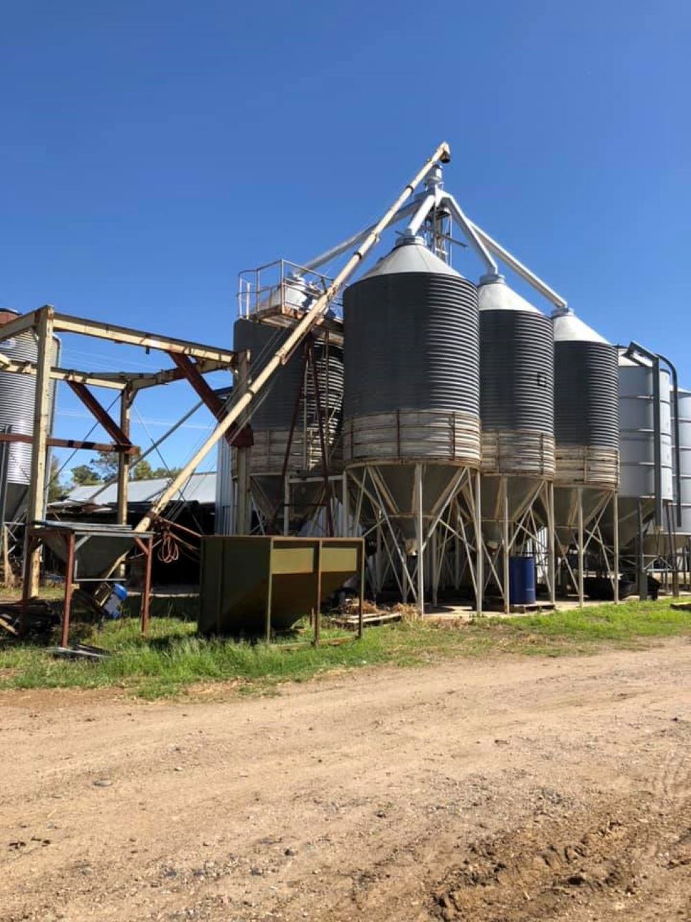 A Row of Silos Sitting on Top of a Dirt Road — Wallamore Grain & Produce In Quirindi, NSW