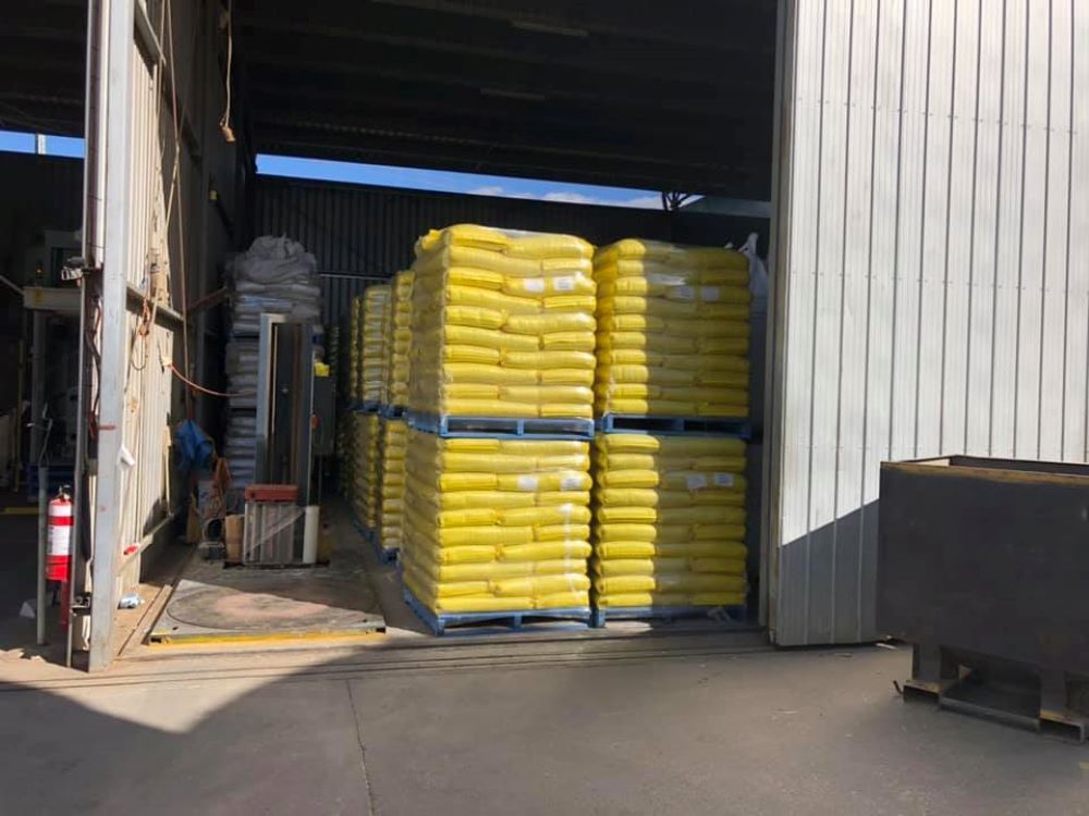 A Warehouse Filled With Lots of Yellow Bags on Pallets — Wallamore Grain & Produce In Wallamore, NSW