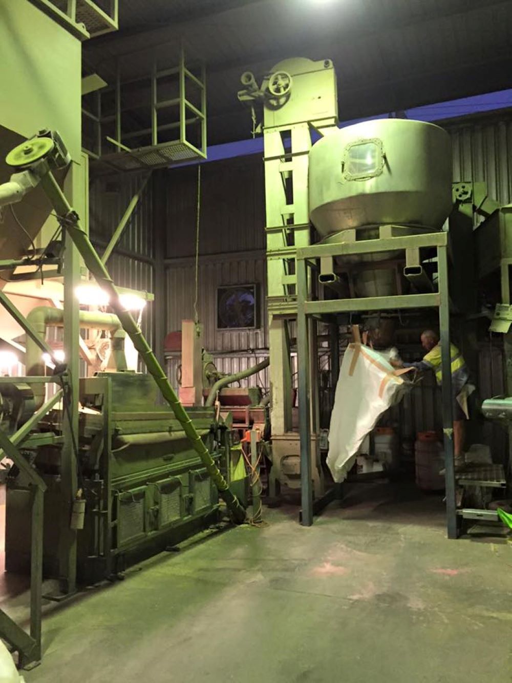 A Man is Standing in Front of a Machine in a Factory — Wallamore Grain & Produce In Wallamore, NSW