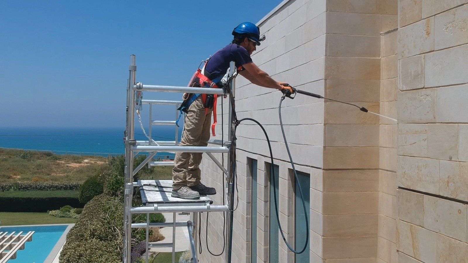stone walls exterior cleaning using power wash, work at height.