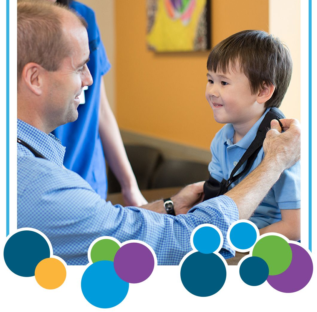 A doctor is checking a little boy with an arm cast.