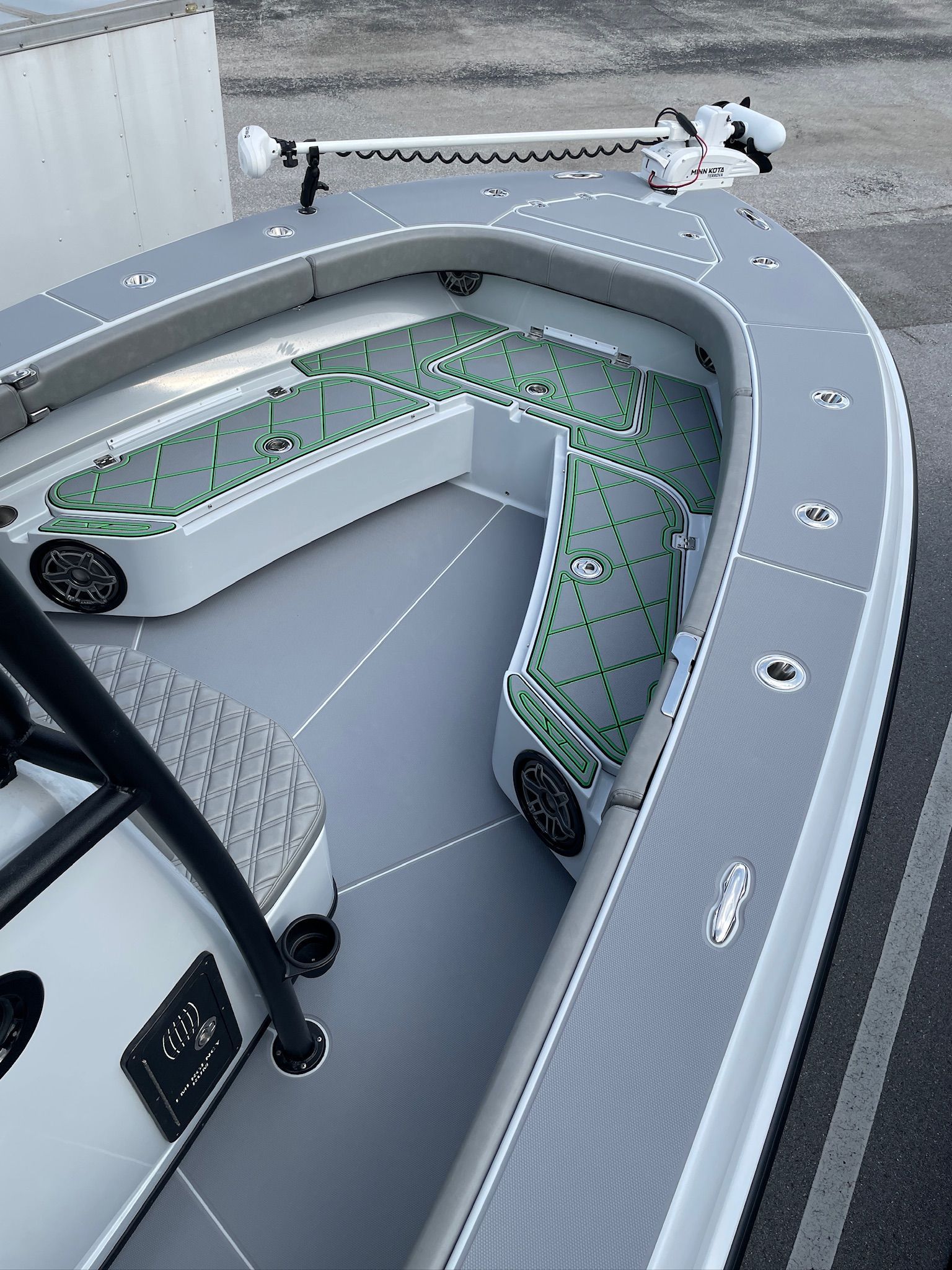 Gray and white fishing boat interior. Green accents on the seating, grey decking.