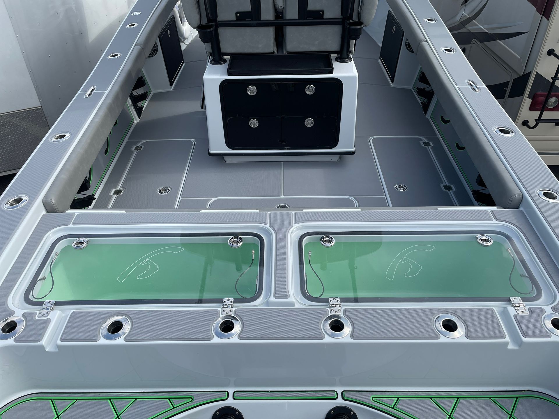 Gray and black boat deck with two rectangular windows and fishing rod holders.