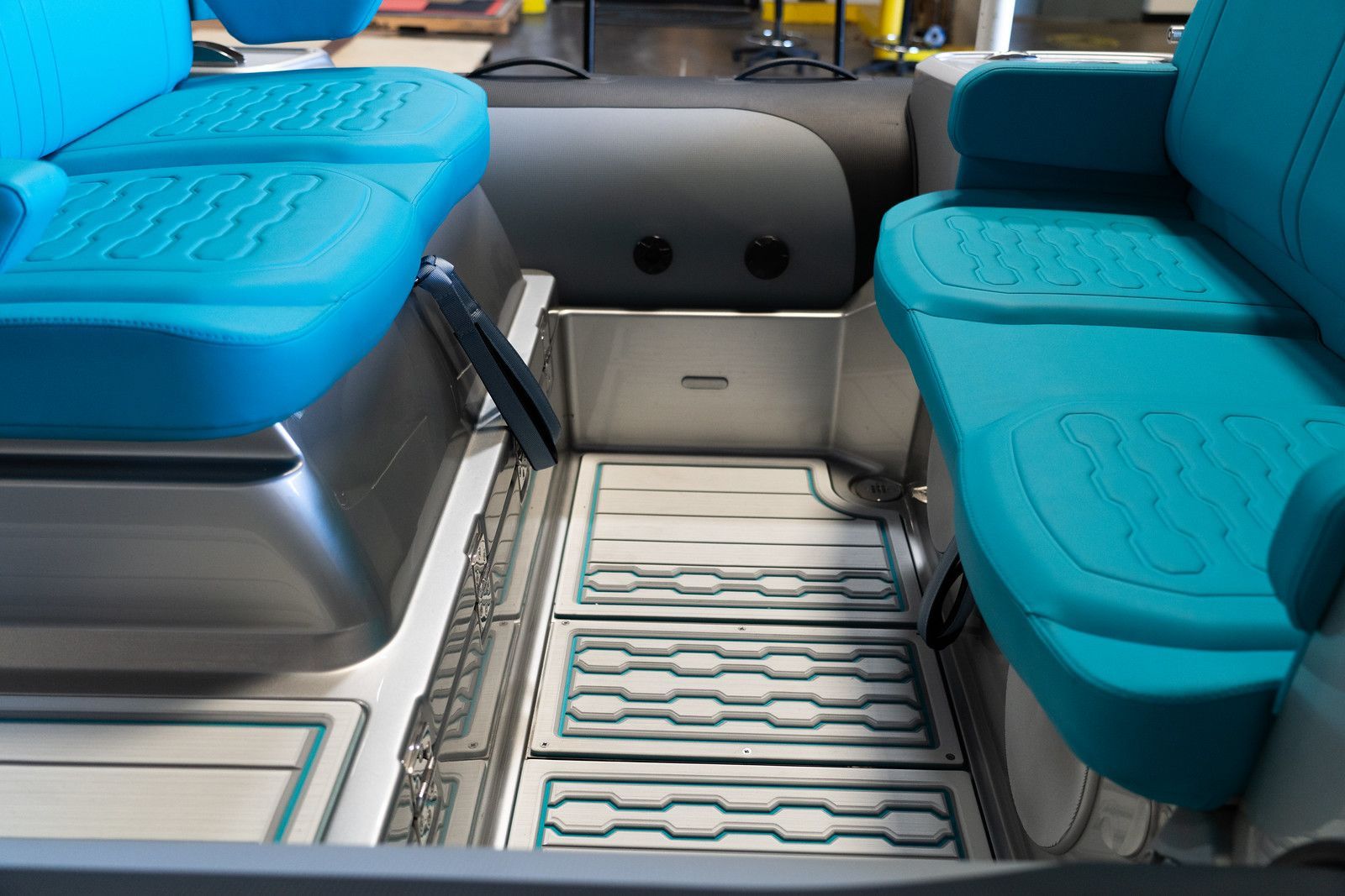 Interior view of a vehicle with teal seats and a metal floor, designed for accessibility.
