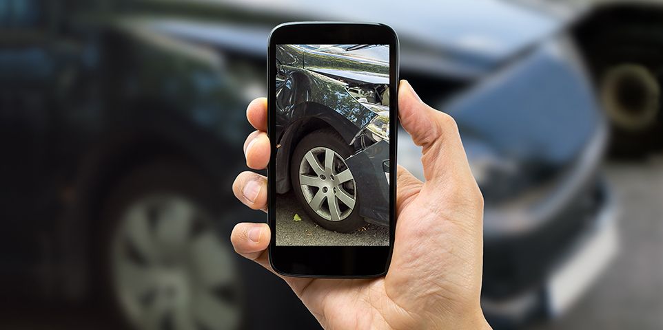 Person taking a photo of car damage