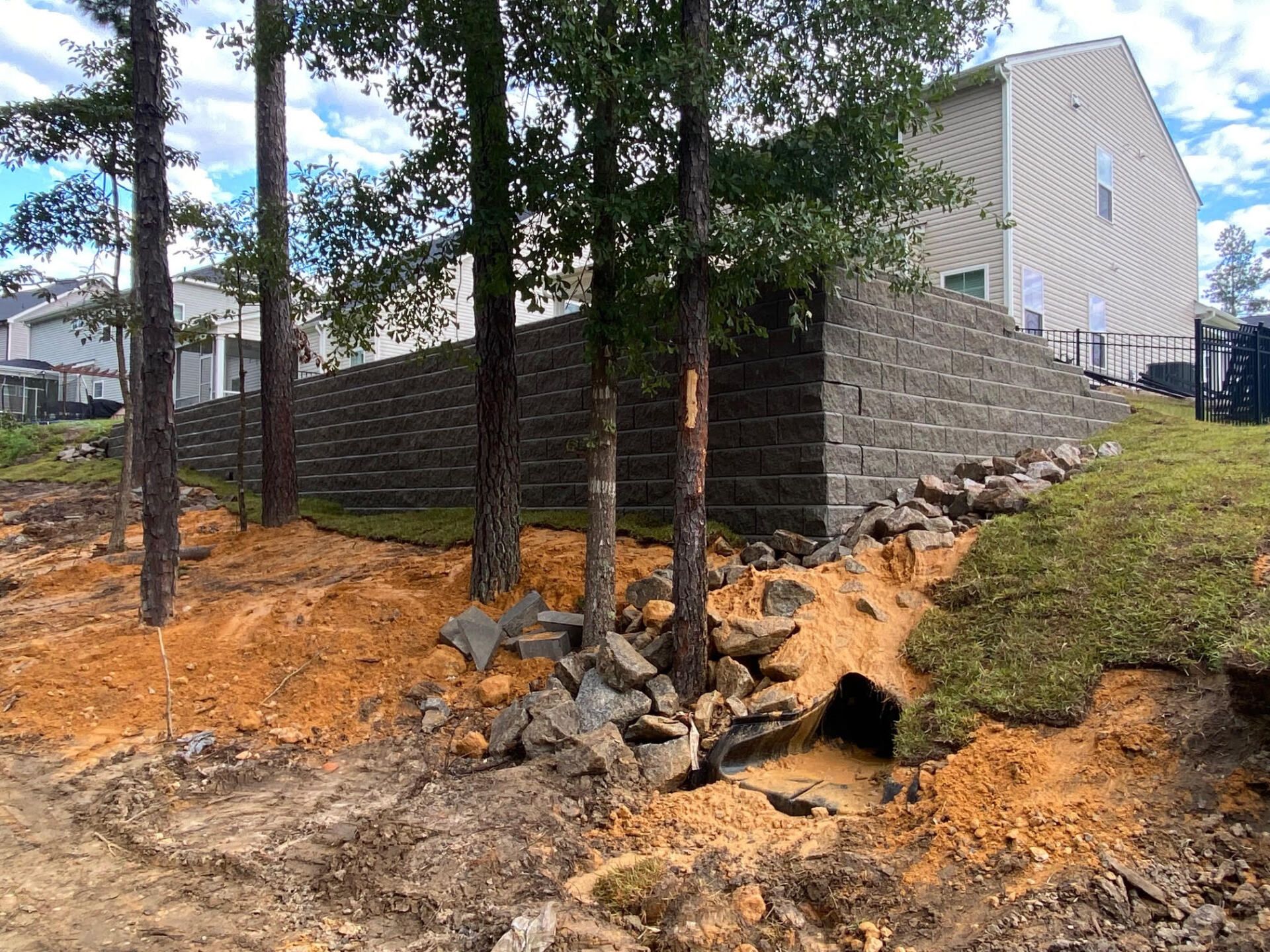 A brick wall is being built in the backyard of a house.