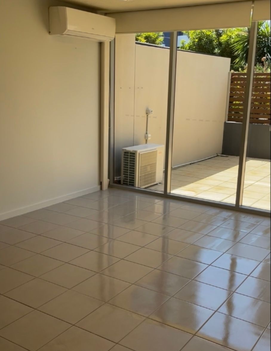 An empty room with a sliding glass door leading to a patio — Solo Reno Coatings In Gold Coast, QLD