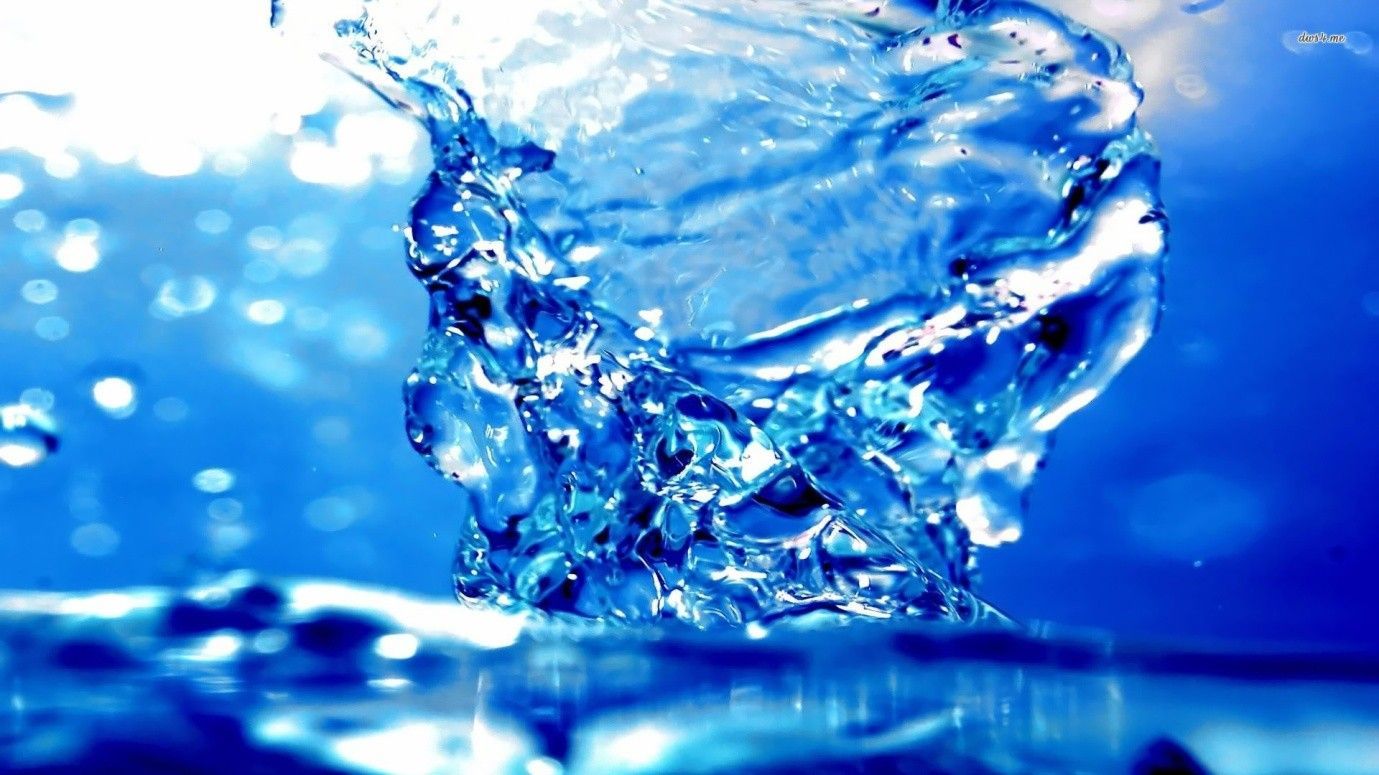 Splashing blue water erupts from an underwater surface, with droplets and a bright blue sky.
