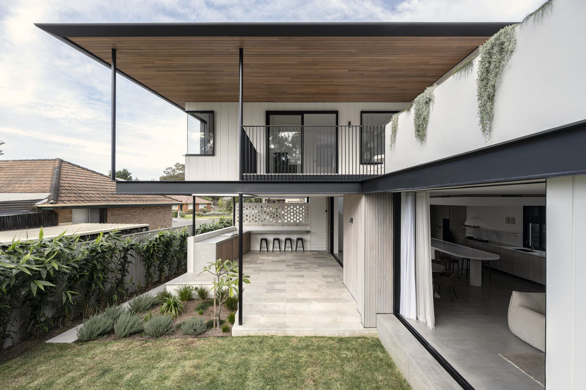 A modern house with a lot of windows is surrounded by trees — DeBu Studios In Southern Sydney, NSW