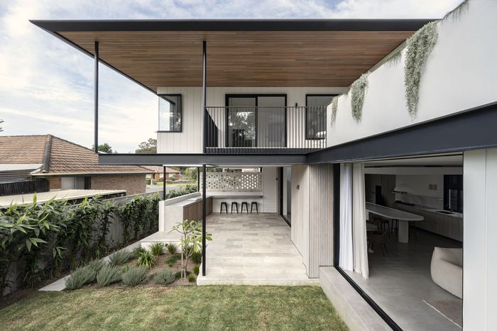 A modern house with a lot of windows is surrounded by trees — DeBu Studios In Southern Sydney, NSW