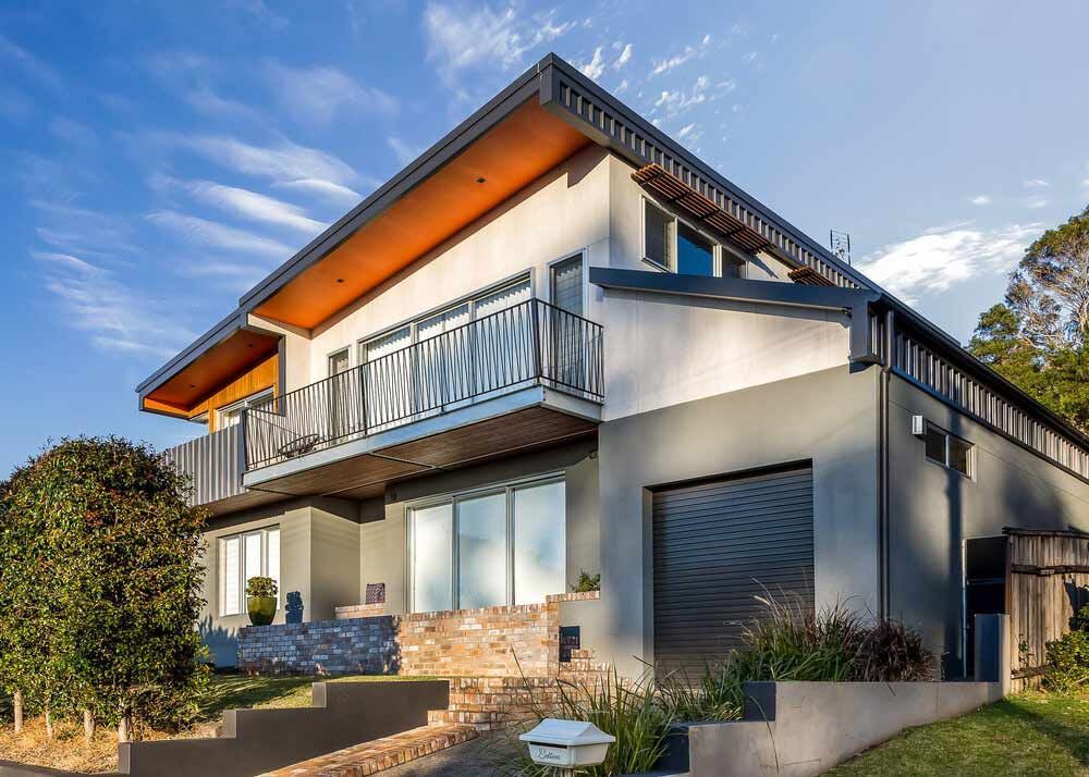 A Large House With a Balcony and a Garage is Sitting on Top of a Hill — DeBu Studios In Russell Vale, NSW