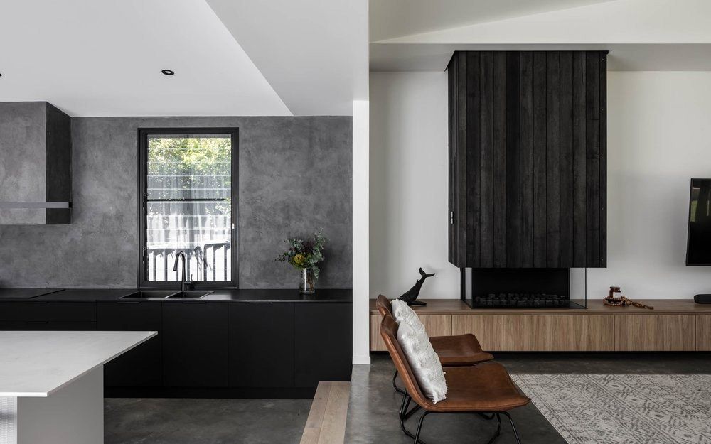 A Living Room With a Chair, Table, Fireplace and Television — DeBu Studios In Russell Vale, NSW