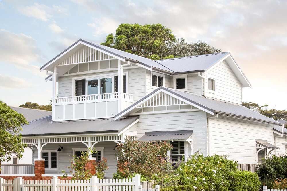 A Large White House With a Gray Roof and a White Picket Fence — DeBu Studios In Russell Vale, NSW