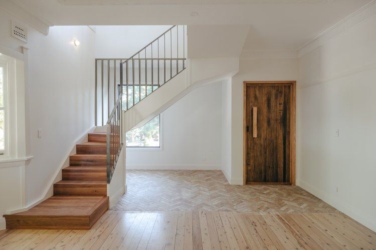 An Empty Room With Wooden Stairs and a Wooden Door — DeBu Studios In Russell Vale, NSW