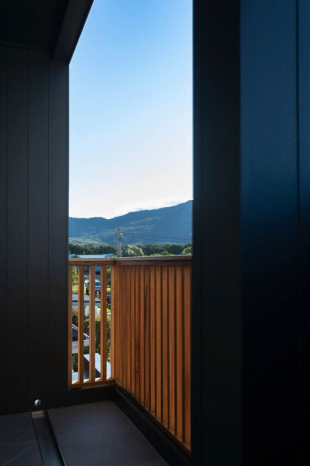 A Balcony With a Wooden Railing and a View of the Mountains — DeBu Studios In Russell Vale, NSW