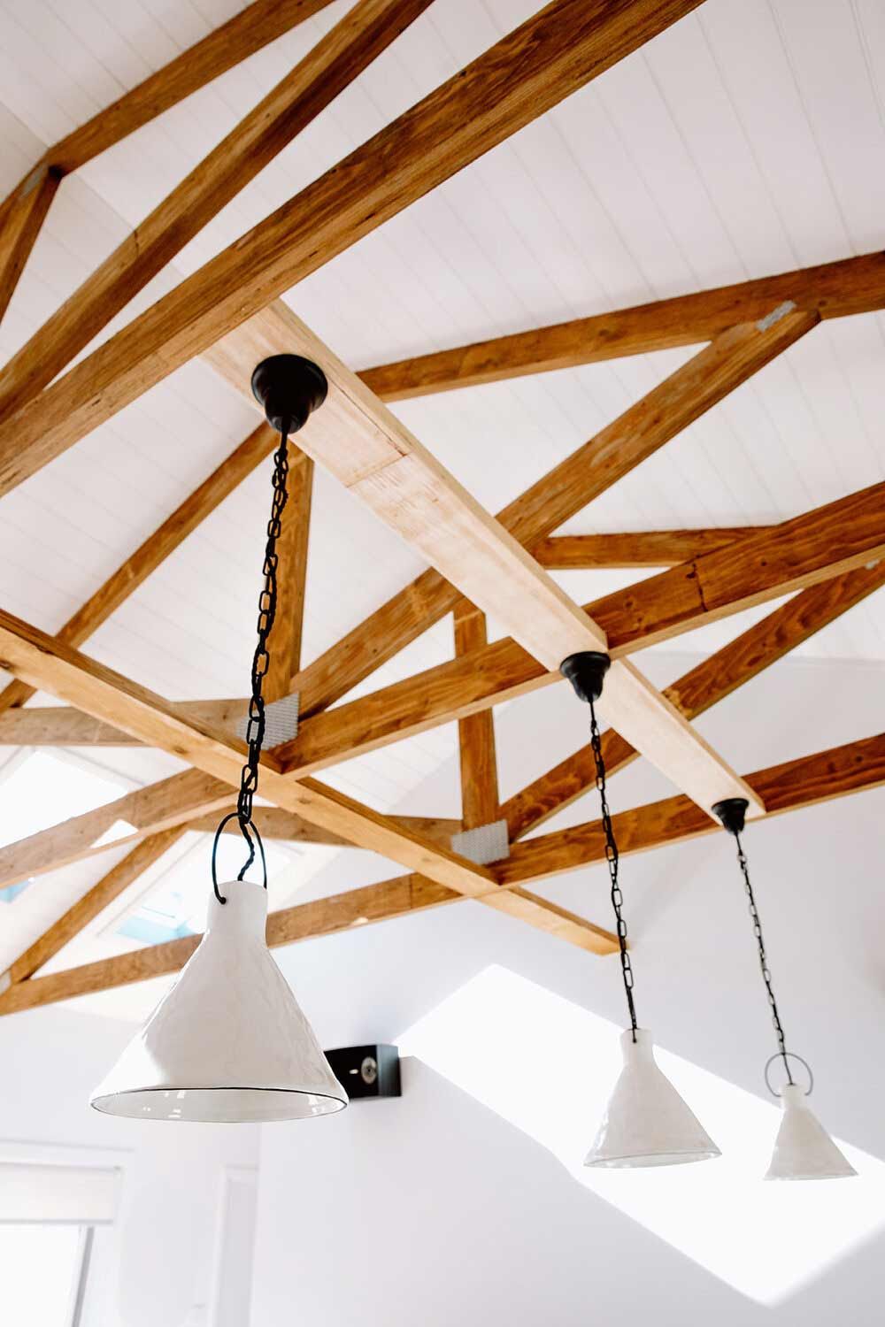 A Ceiling With Wooden Beams and White Lights Hanging From It — DeBu Studios In Russell Vale, NSW