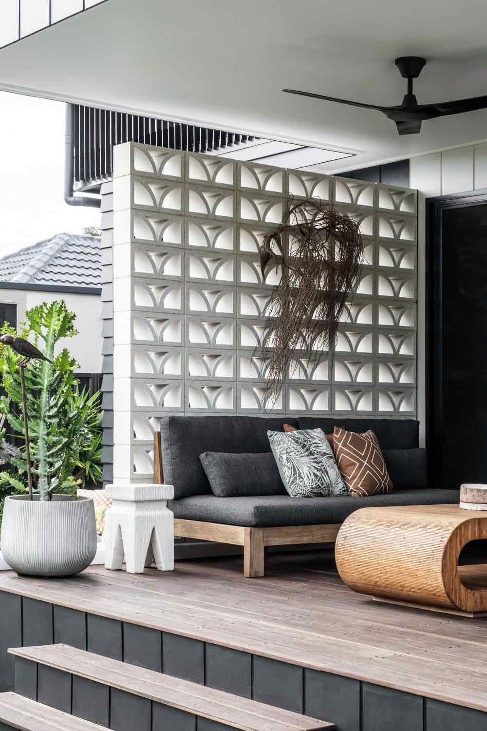 A Patio With a Couch, Coffee Table, and Potted Plants — DeBu Studios In Russell Vale, NSW