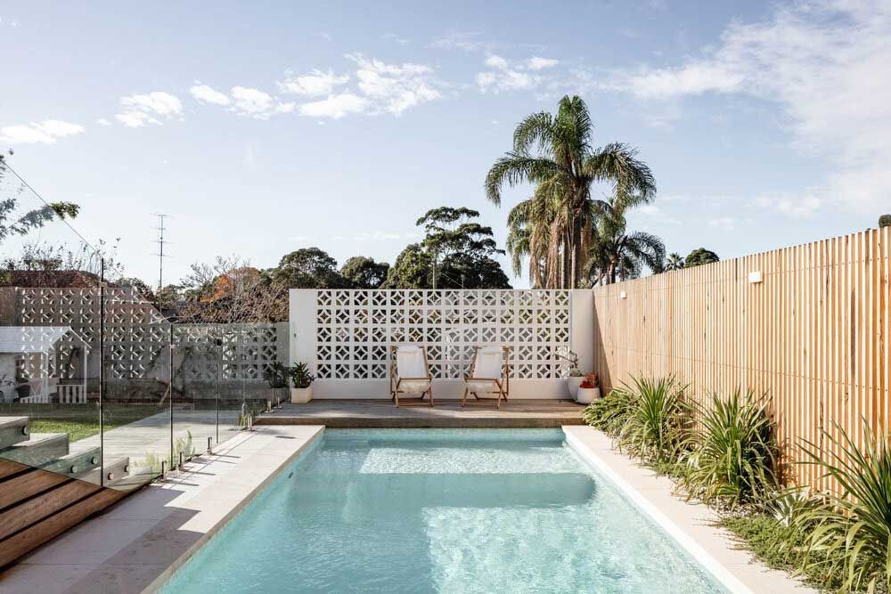 A Large Swimming Pool is Surrounded by a Wooden Fence — DeBu Studios In Russell Vale, NSW