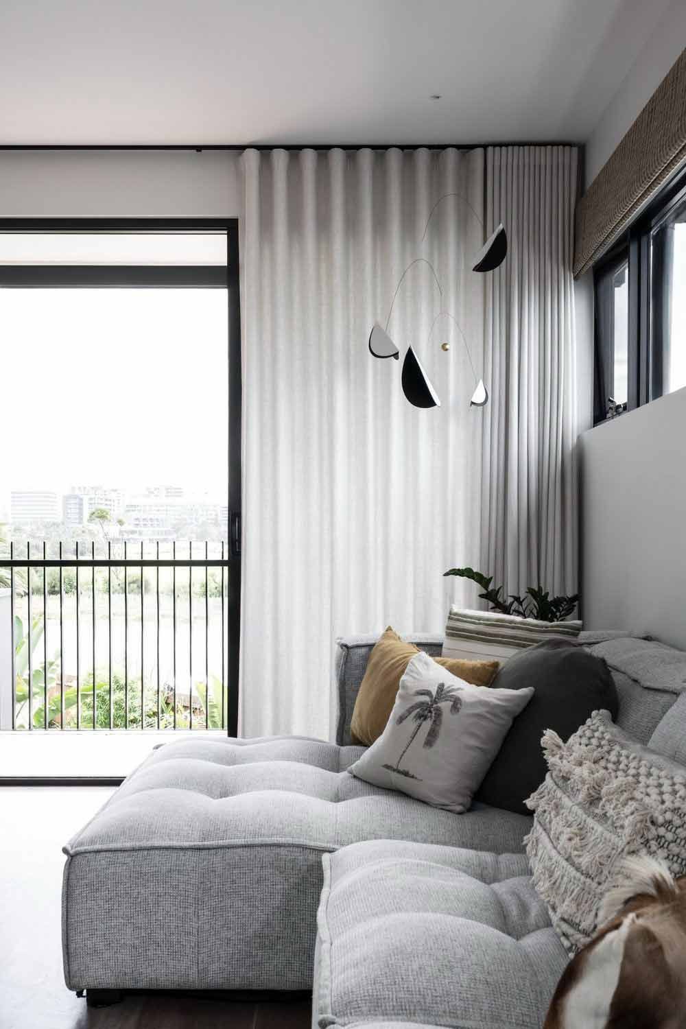 A Living Room With a Couch , Curtains and a Balcony — DeBu Studios In Russell Vale, NSW