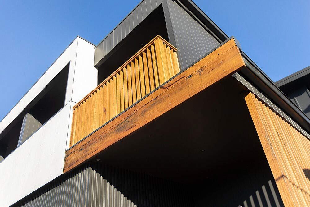 A Black and White Building With a Wooden Balcony — DeBu Studios In Russell Vale, NSW