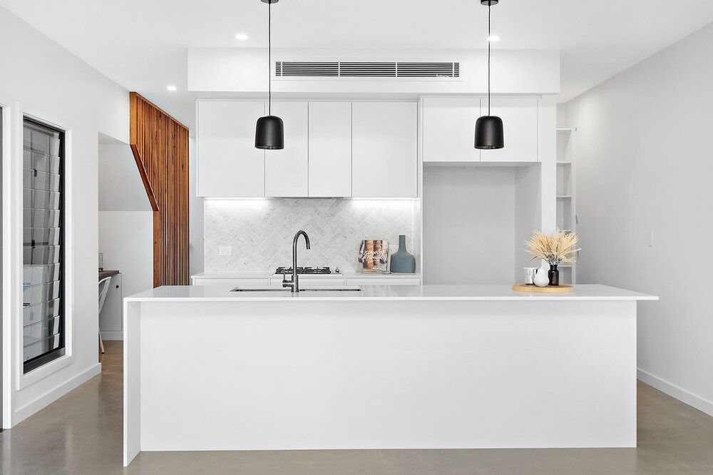 A Kitchen With White Cabinets and a Large Island — DeBu Studios In Russell Vale, NSW