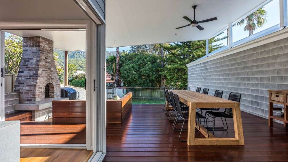 There is a Large Wooden Table and Chairs on the Deck — DeBu Studios In Russell Vale, NSW