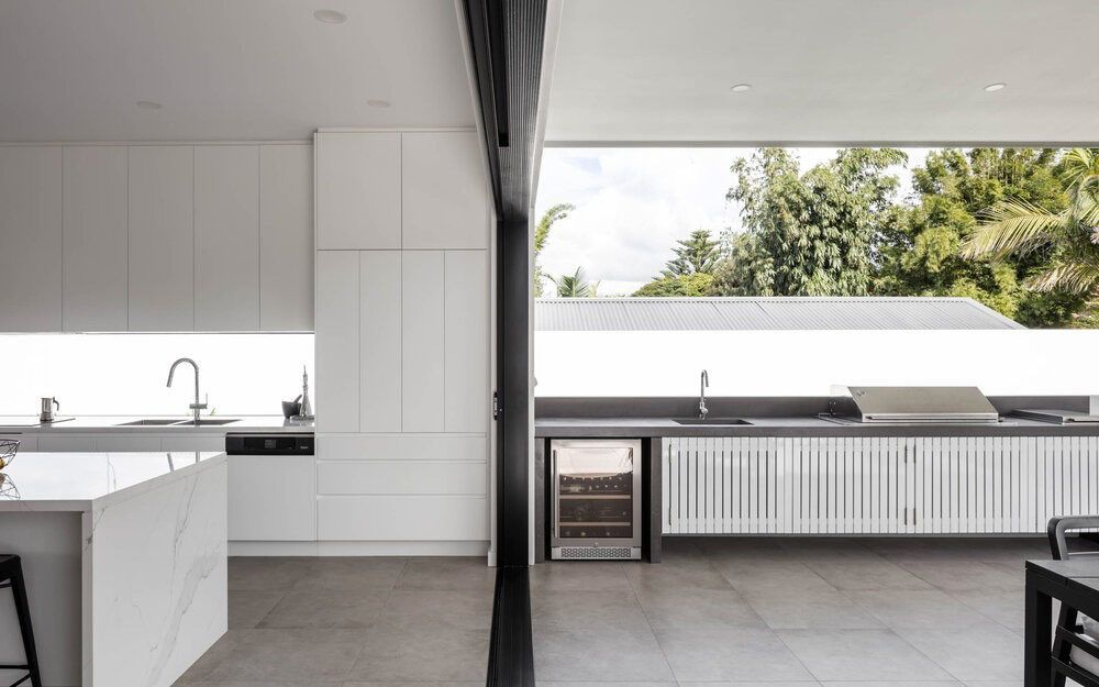 A Kitchen With White Cabinets and a Sliding Glass Door — DeBu Studios In Russell Vale, NSW