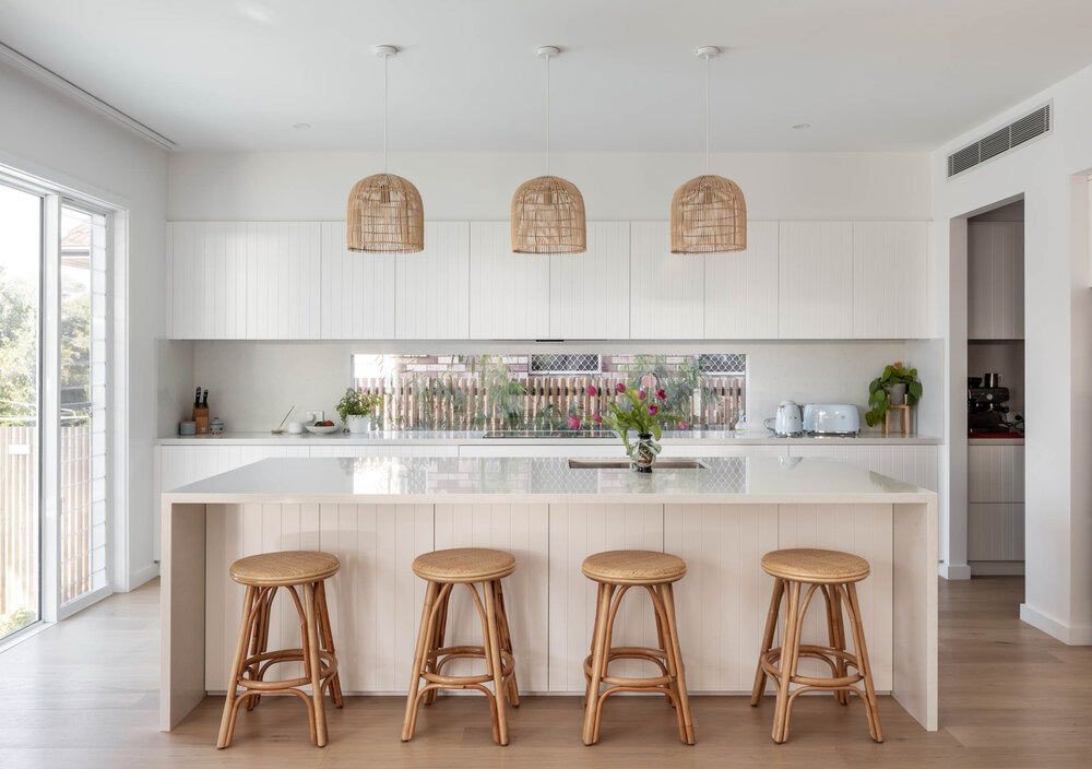 A Kitchen With White Cabinets and Wooden Stools Around the Island — DeBu Studios In Russell Vale, NSW