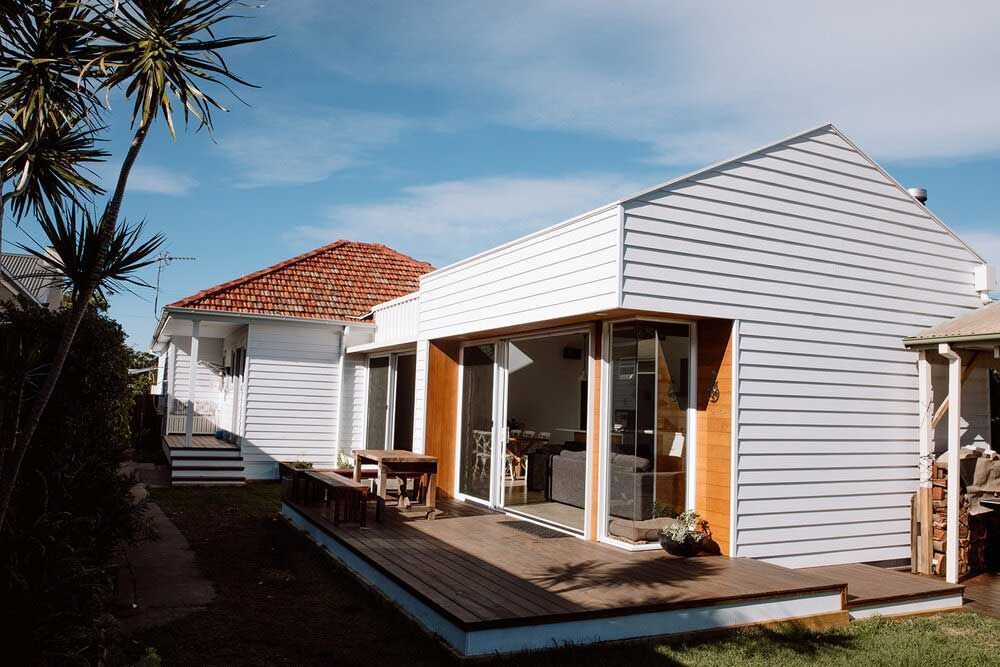 A White House With a Wooden Deck in Front of It — DeBu Studios In Russell Vale, NSW