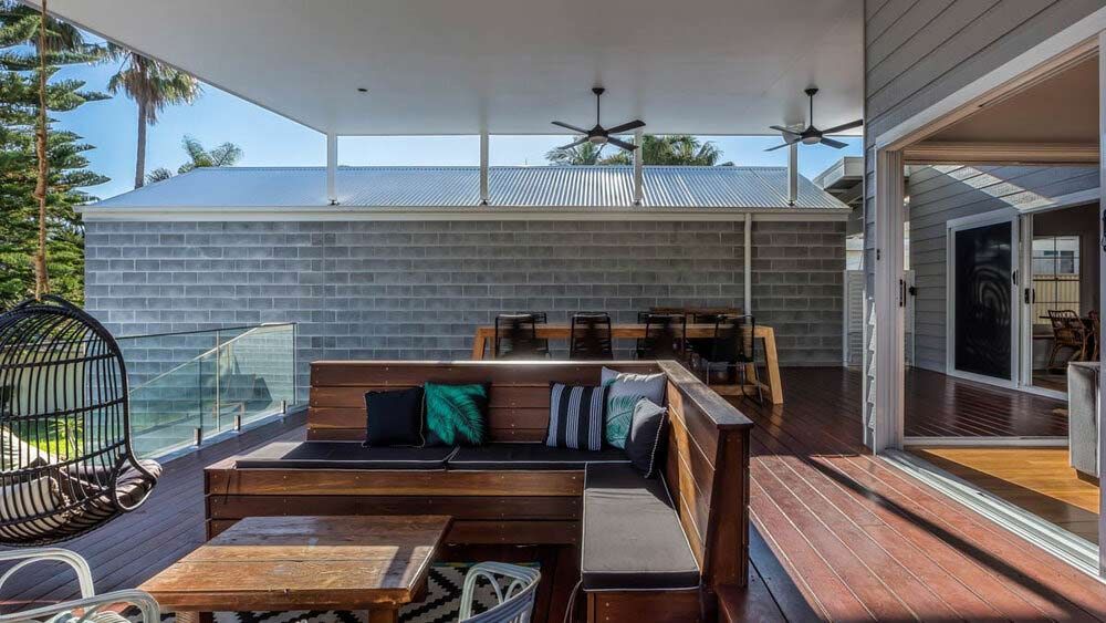 A Large Deck With a Couch , Table and Chairs on It — DeBu Studios In Russell Vale, NSW