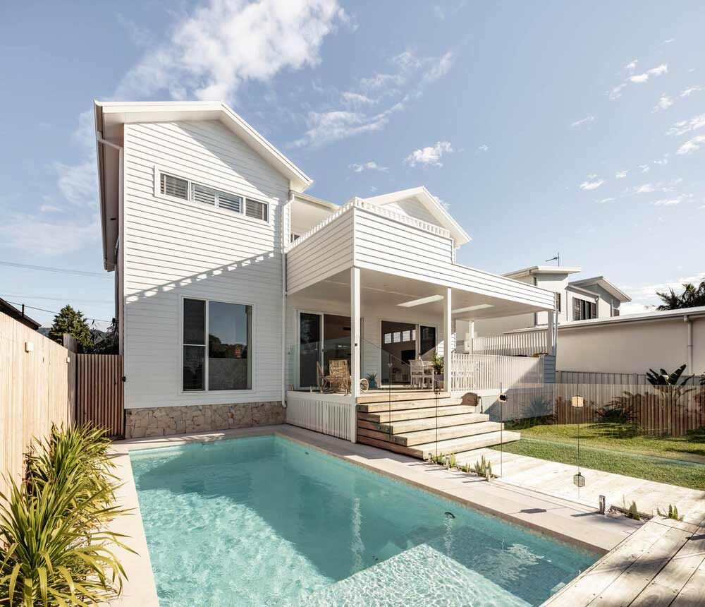 A White House With a Large Swimming Pool in Front of It — DeBu Studios In Russell Vale, NSW