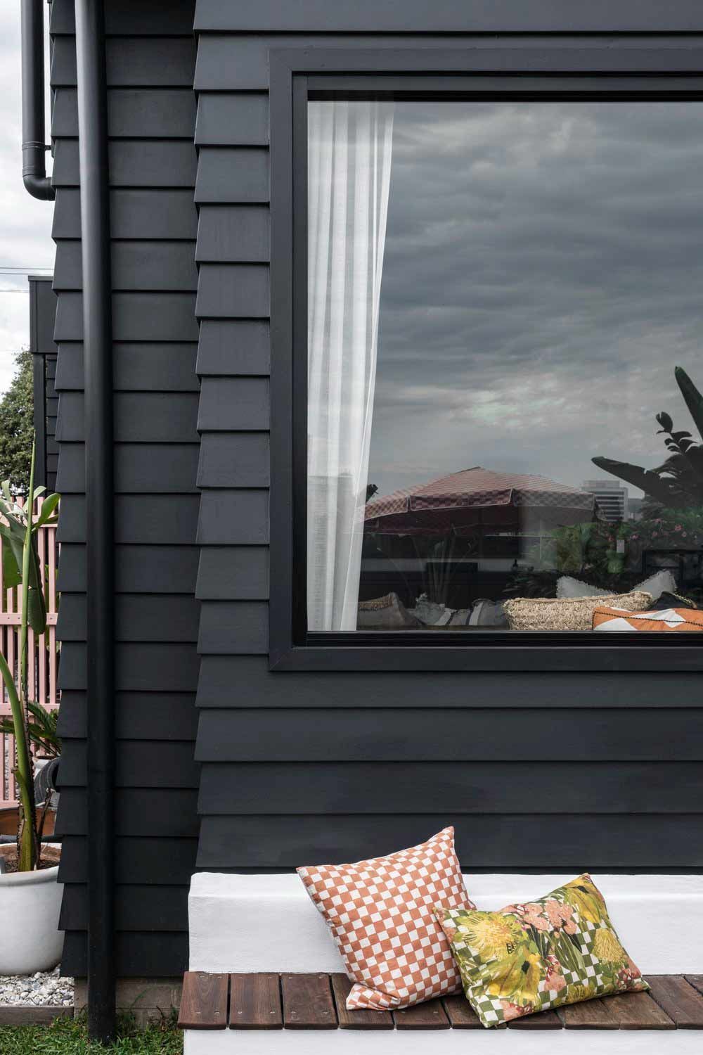 A Black House With a Large Window and a Bench With Pillows on It — DeBu Studios In Russell Vale, NSW