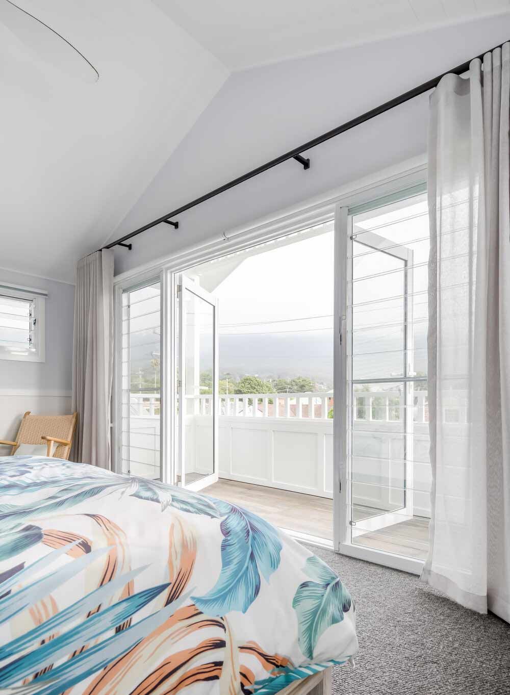 A Bedroom With a Bed, Chair and Sliding Glass Doors — DeBu Studios In Russell Vale, NSW