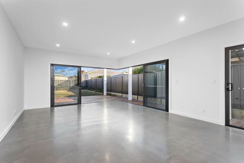 An Empty Living Room With Sliding Glass Doors — DeBu Studios In Russell Vale, NSW
