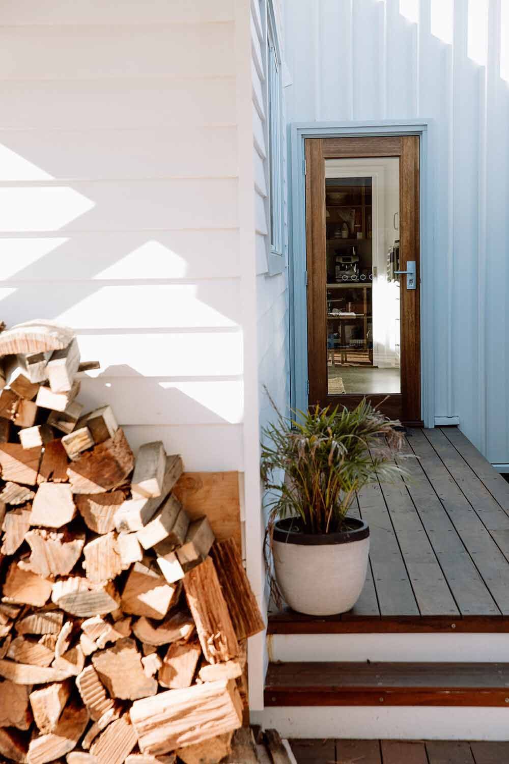 A Pile of Wood is Sitting on a Porch Next to a Potted Plant — DeBu Studios In Russell Vale, NSW