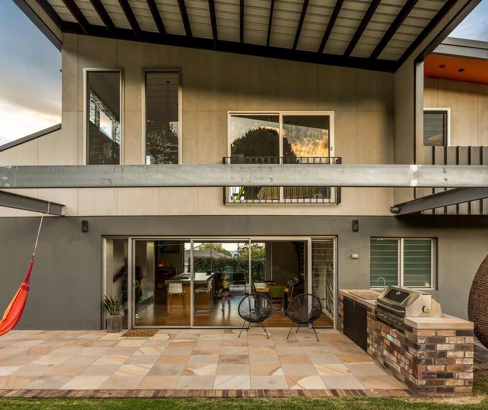 A Large House With a Patio and Chairs in Front of It — DeBu Studios In Russell Vale, NSW