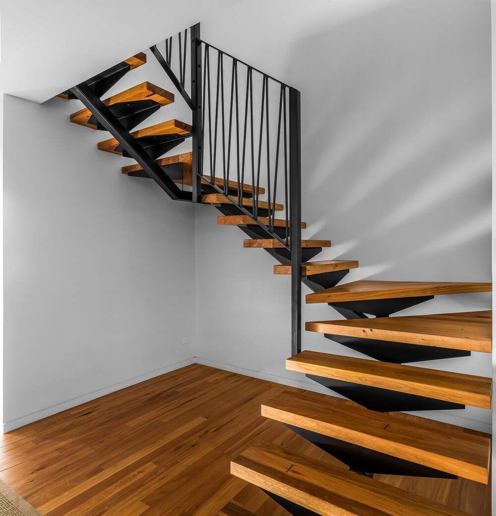 A Wooden Staircase With a Metal Railing in a Room — DeBu Studios In Russell Vale, NSW