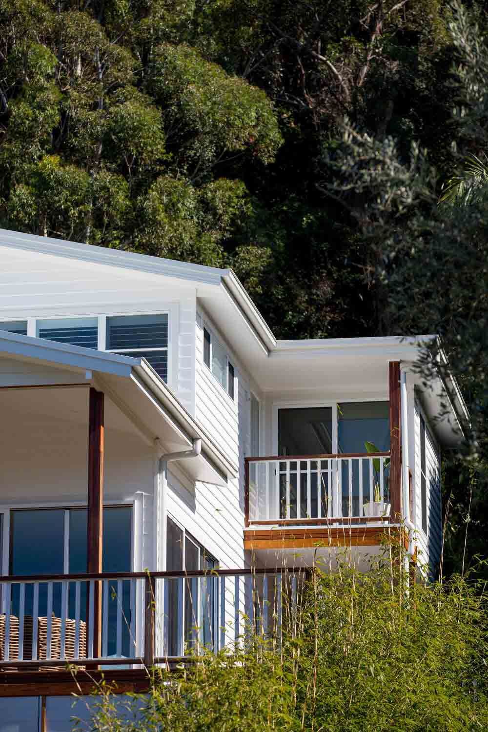 A White House With a Balcony is Surrounded by Trees — DeBu Studios In Russell Vale, NSW
