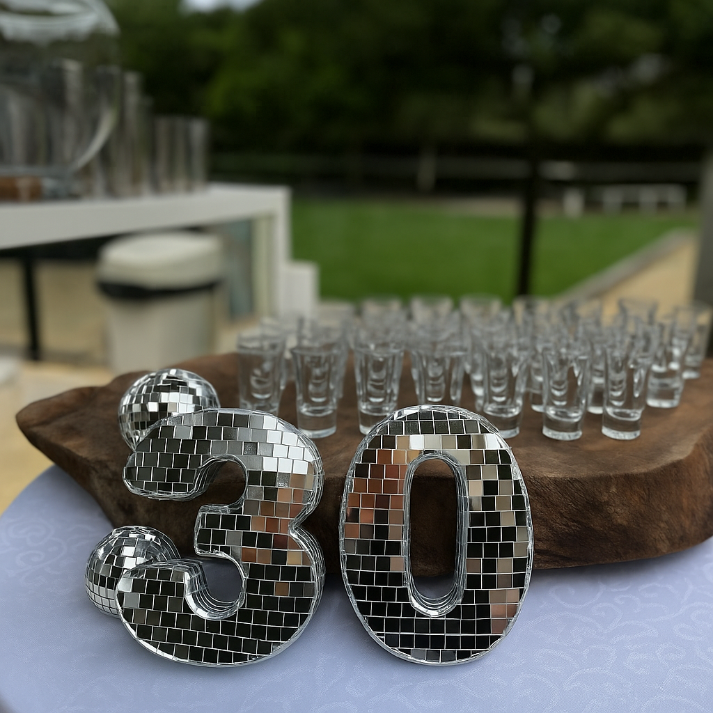 Centro de mesa com bola de discoteca e o número “30”