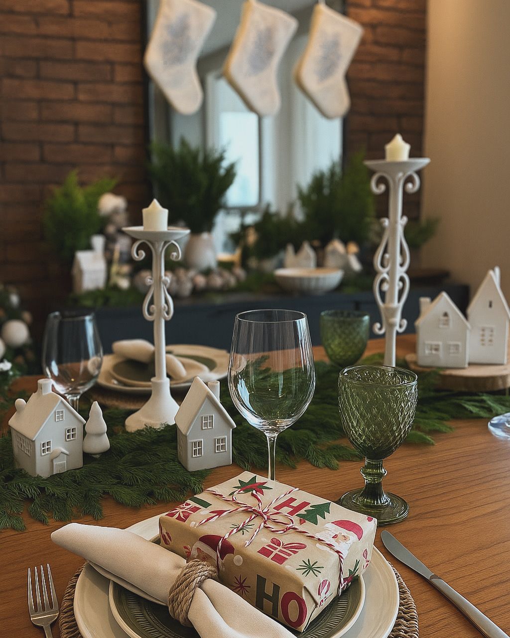 Mesa de jantar festiva com meias de Natal, velas e decoração natalina em um ambiente aconchegante.