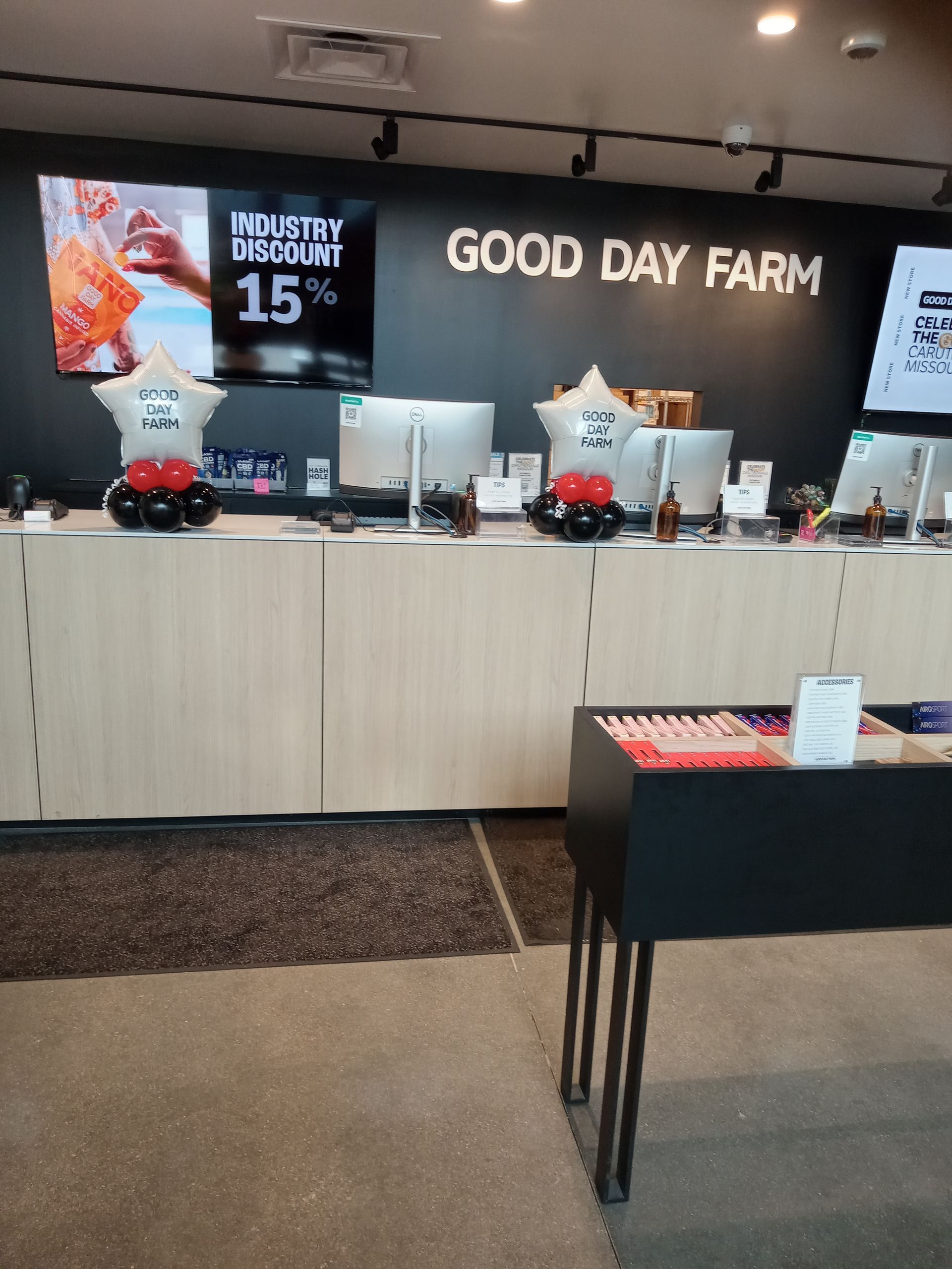 Good Day Farm booth with black backdrop, display counter, and promotional signs at an indoor event.