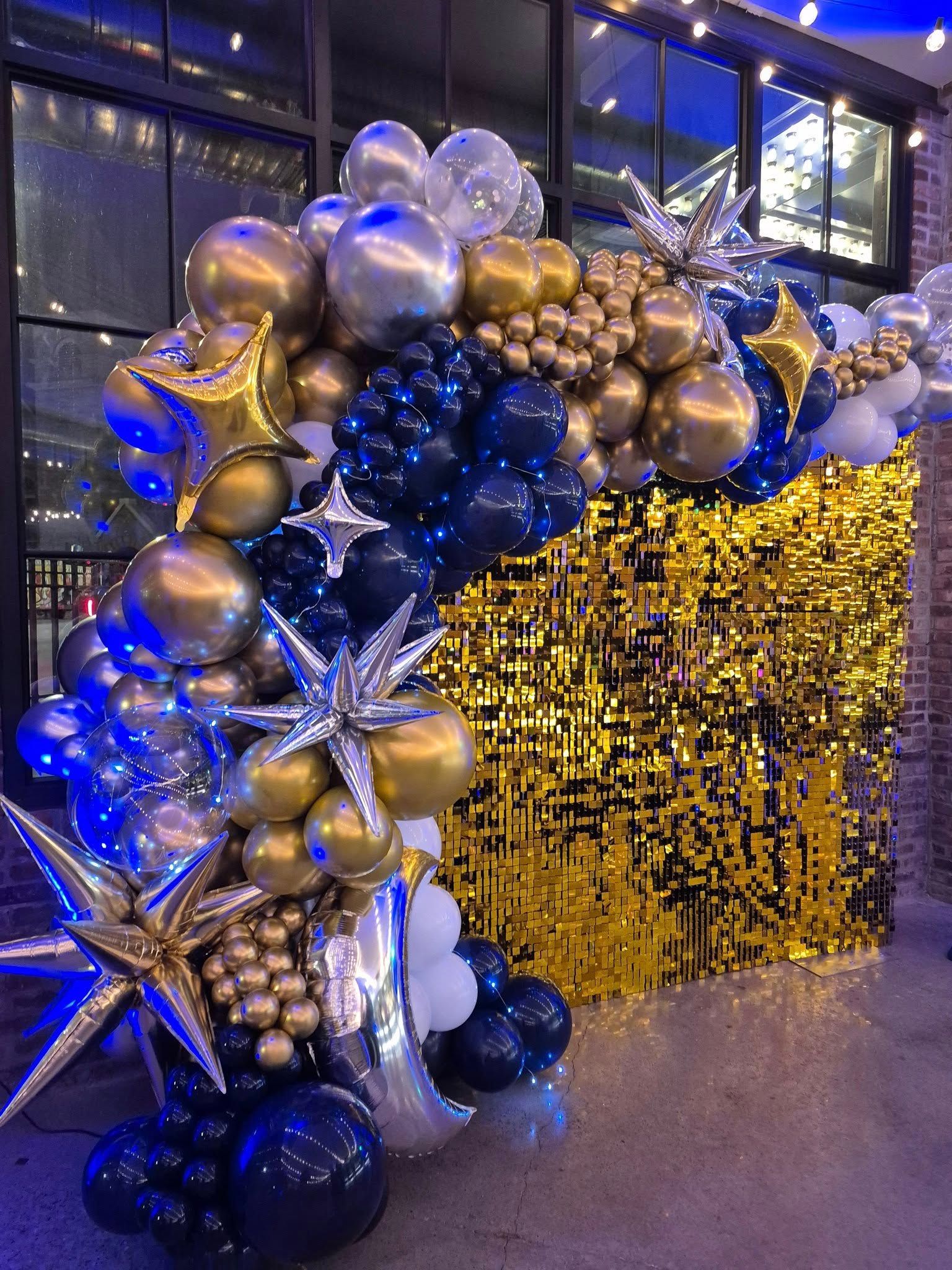 Blue, gold, and silver balloon garland and star decorations at a festive entrance display