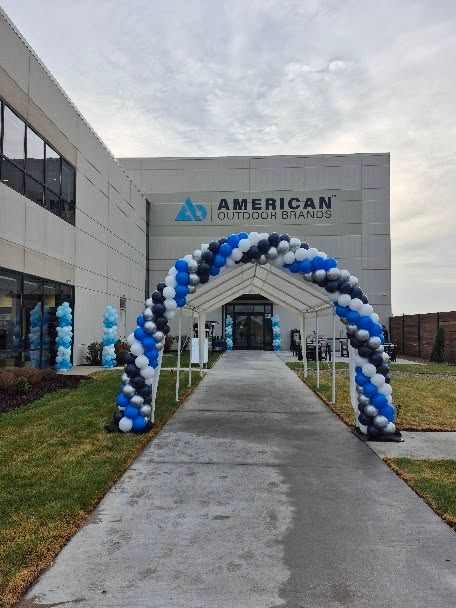 Blue-and-white balloon arch at the entrance of American Billiards in front of a building