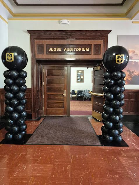 Entrance to Jesse Auditorium with black balloon columns framing the doorway