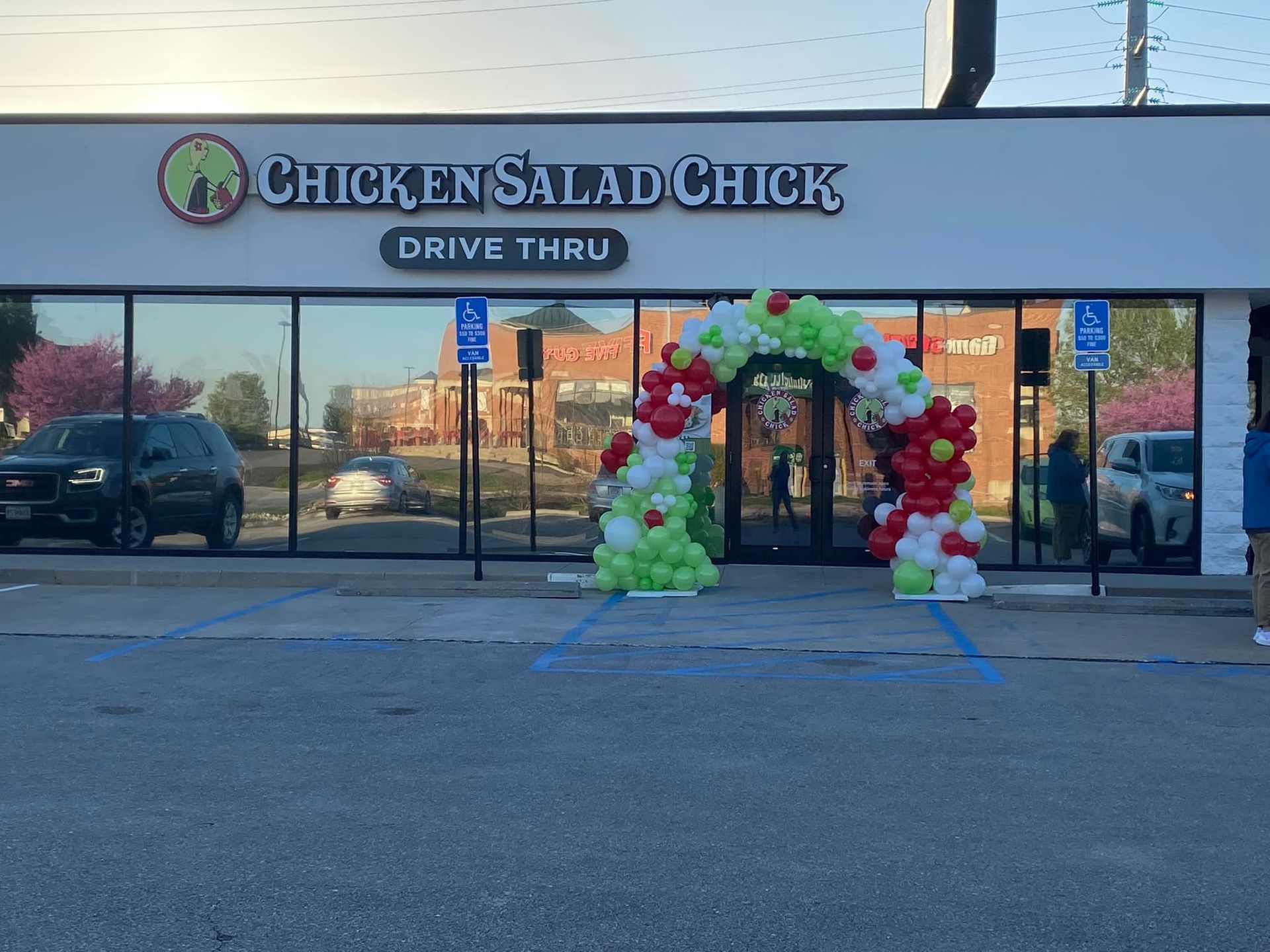 Chicken Salad Chick drive-thru storefront with a colorful balloon arch at the entrance