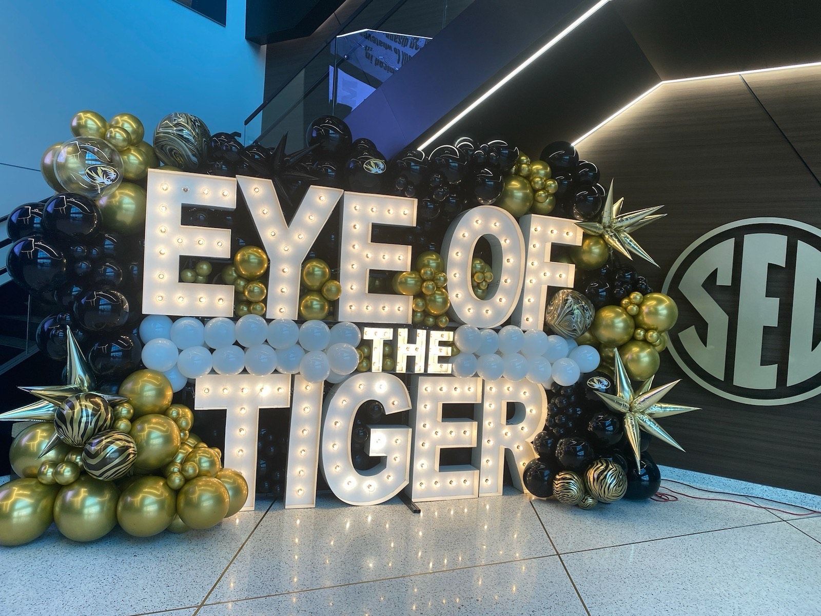 “Eye of the Tiger” sign with gold balloons at a theater entrance