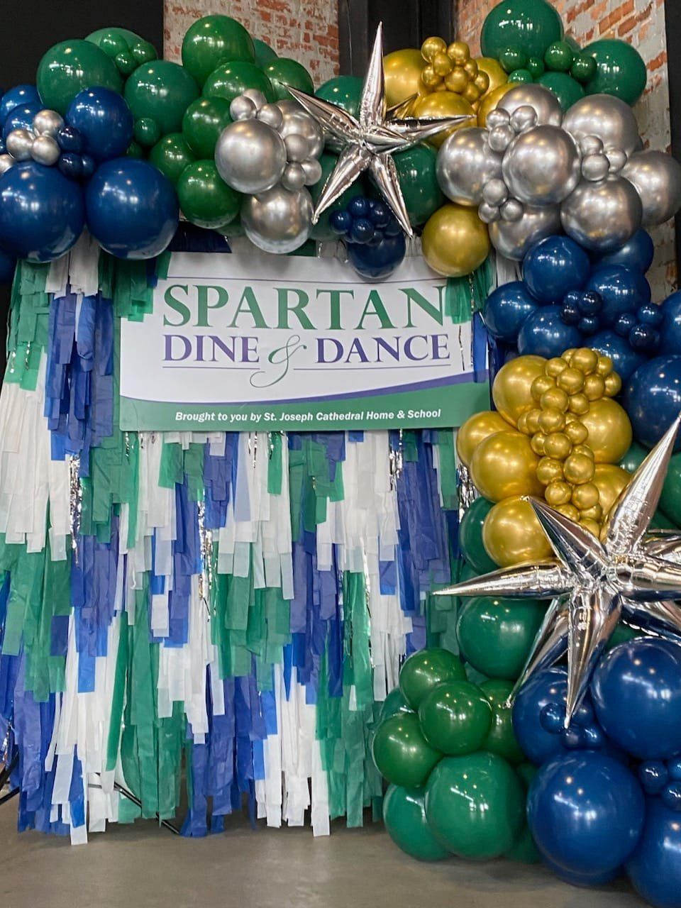 Spartan Dine & Dance balloon backdrop with green, blue, silver and gold decorations